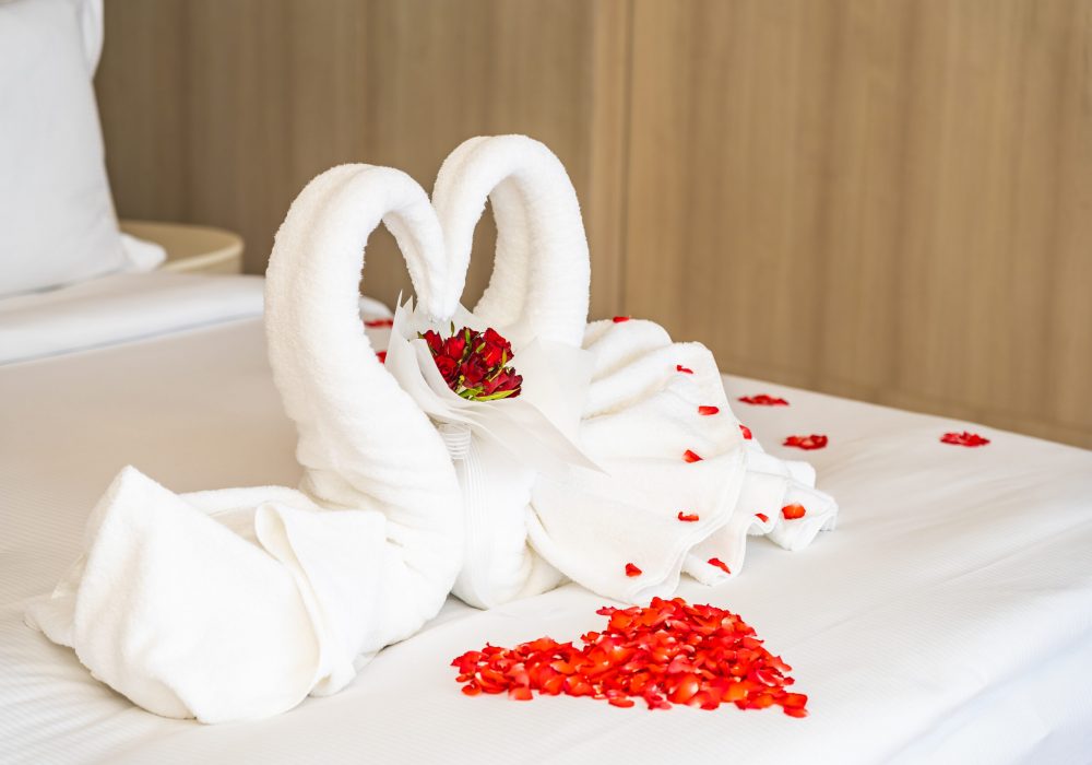 Swan towel on bed with red rose flower decoration interior of bedroom